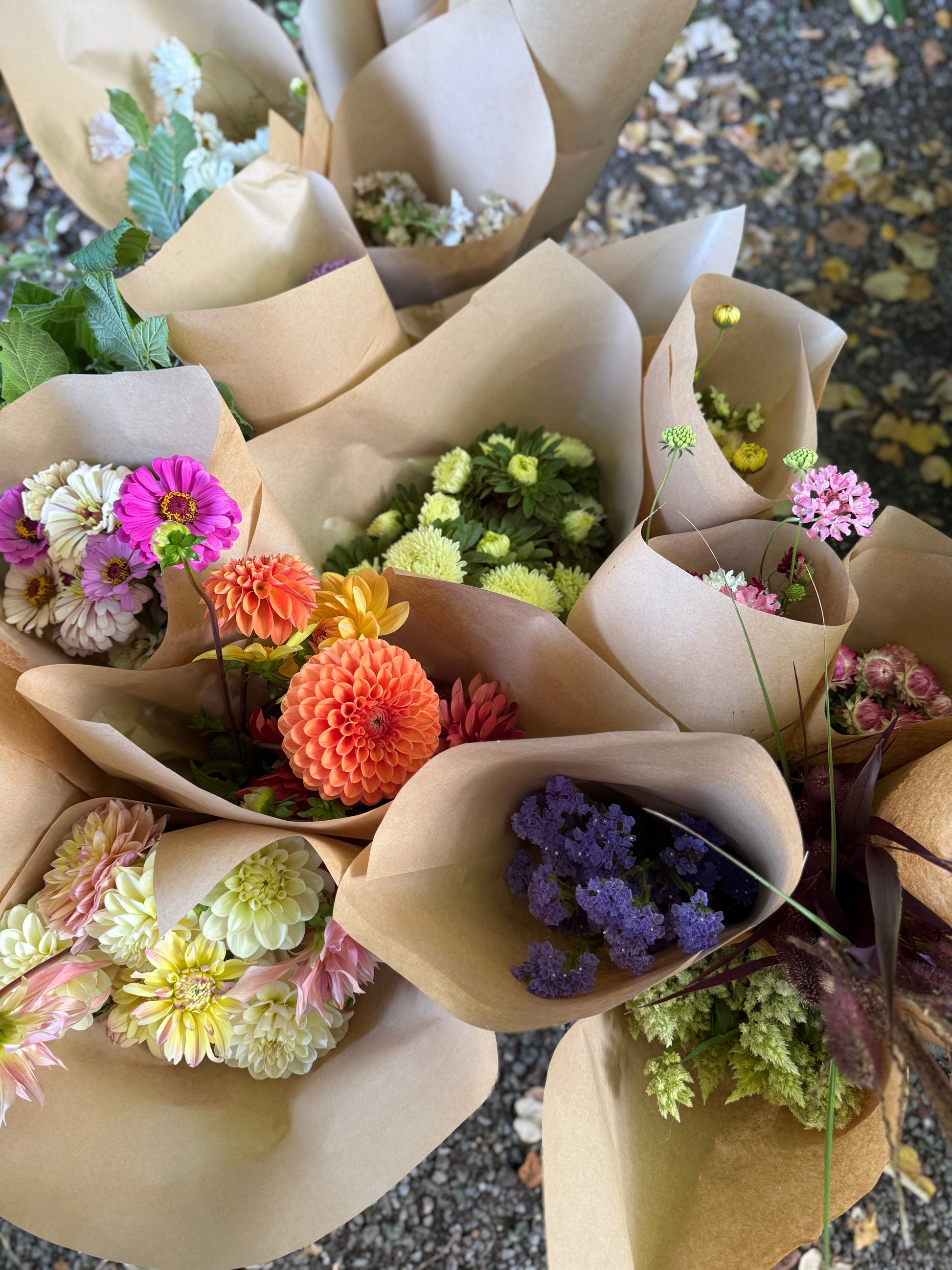 Bouquets of flowers wrapped in brown paper on a textured surface
